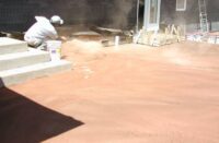 Throwing Color Hardener onto concrete for a non gray looking concrete slab.