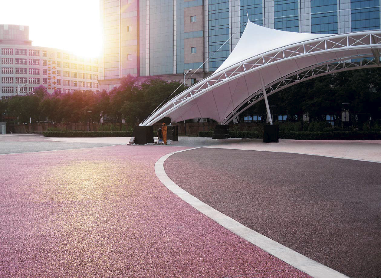 A band of traditional concrete installed between colored pervious sections, as seen in downtown Beijing at the Olympics staging area.