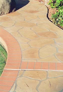 Curved concrete walkway brick bordering stone look. Stamped concrete with brick border.