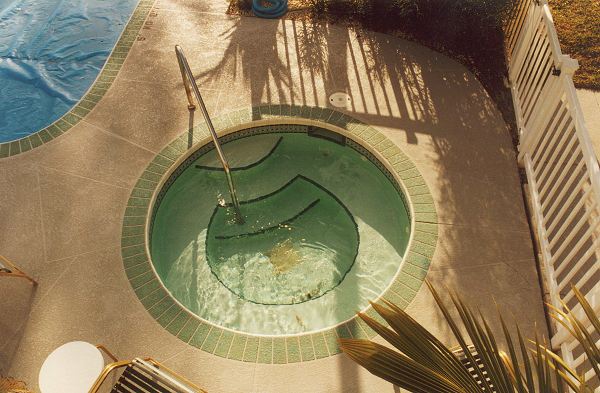 The surface leading up to this residential pool and hot tub has been treated by Increte Systems Spray-Deck textured concrete overlay system.