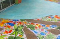 Concrete overlay in sea blue by Butterfield Color guides visitors to the entrance of an after school program in San Antonio, Texas.