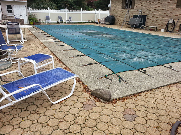 The old pavers had settled, but the concrete pool coping was still in good shape. The Fishers had to maneuver material in the tight space between the pool and the fence.