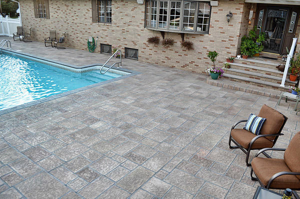 If you look closely, you can see a straight line, which is actually a sawcut, running from the middle of the last step through the pool deck. Also to offset the pattern and draw attention to individual shapes, the Fishers hand-applied various stains to each rectangle.
