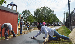 concrete racetrack sidewalk with contractors troweling concrete