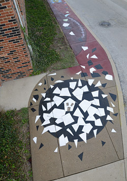concrete sidewalk mosaic with house in center
