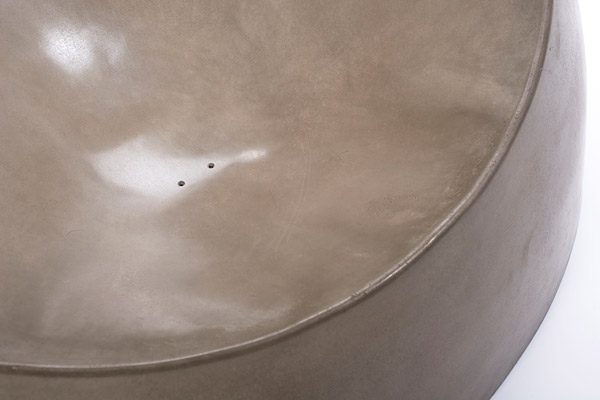 Two holes in the seat of the concrete loungers allow for drainage.