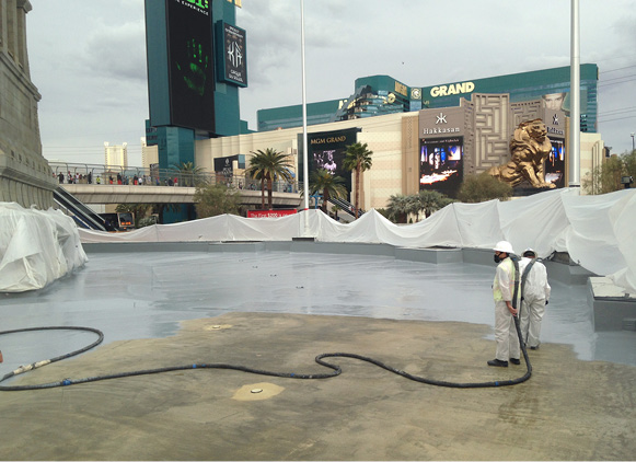 crew applying Versaflex polyurea basecoat to reflecting pool feature