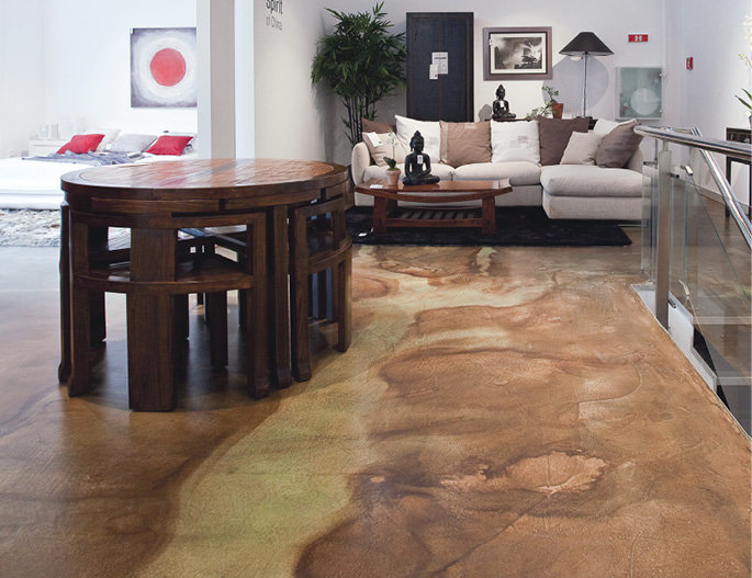 Two tone stained concrete living room floor with oblong table & small chairs.