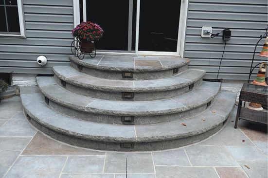 Formed concrete with a edge form on theses rounded steps lead to a back sliding glass door.