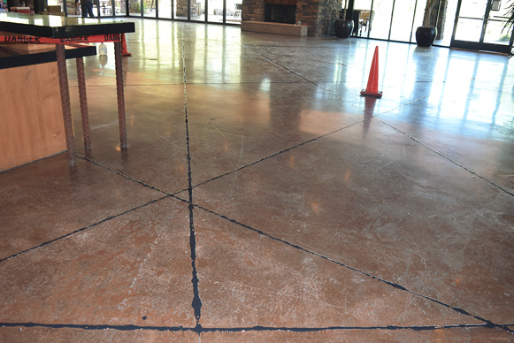 After the black polyurea joint filler had been applied the overfill was cut back and the floor is ready to be ground and polished.