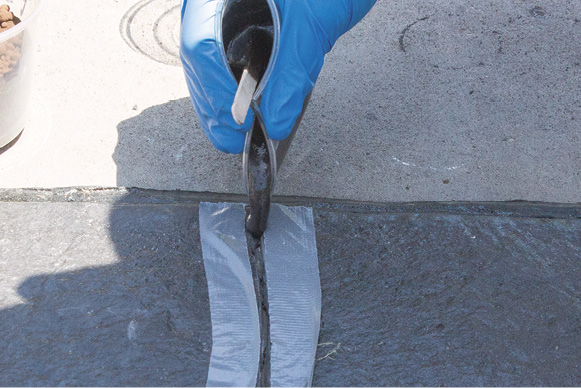 polyurea joint filler. used in a crack with masking around so it does not stain the concrete