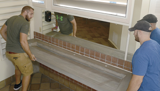 A floating concrete bathroom vanity being installed in a bathroom at the Innnisbrook Resort in Palm Harbor Florida.