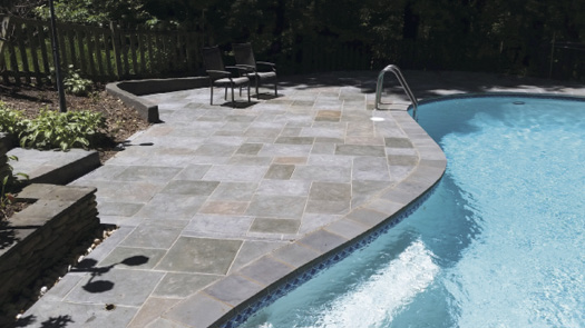 Tired of the high maintenance of their existing stone pavers, the clients opted for multicolored stamped concrete with grouting detail in an Old English Slate pattern and a zero-shine sealer.