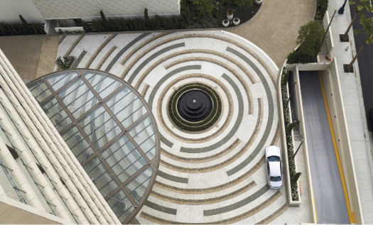To create a dramatic first impression for hotel guests, Trademark installed white color hardener, green integral concrete with seeded granite and natural stone paving in sets of three stacked 26-inch wide bands, each with a different finish.