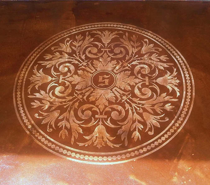 A stenciled logo on stained concrete floor.