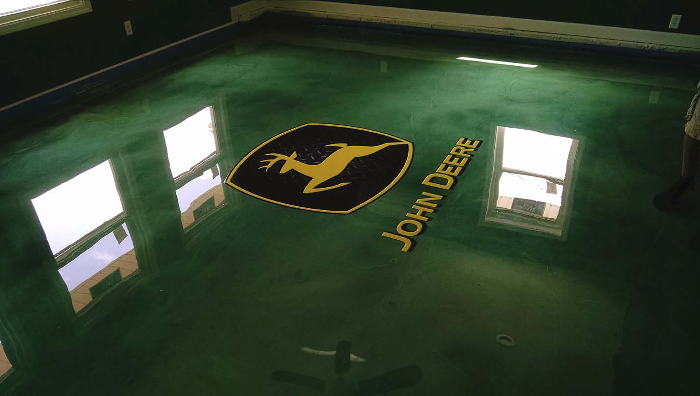 John Deere log on a green epoxy floor.
