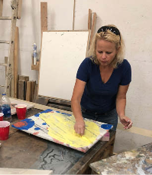 Working in her shop on the concrete paintings.