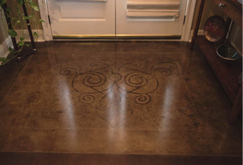Stencil on a concrete in a dark brown on a orangish color floor finish.