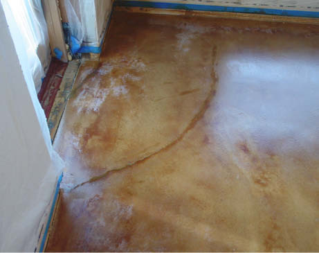 Cold exterior temperatures created a temperature differential on the concrete that led to sealer damage near the door and walls.