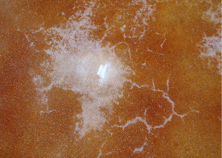 This sealer failure was caused by condensed moisture in a low spot on the floor that created an area that fell below the minimum film-forming temperature.
