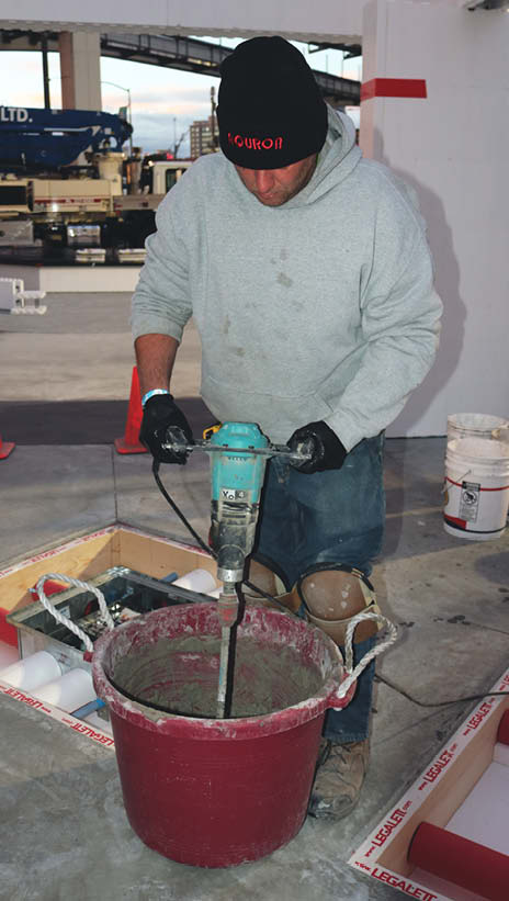 Mixing a bucket of concrete using a Collomix mixer.
