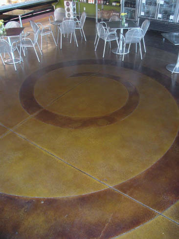 Swirl design on a concrete floor with reds and yellows.