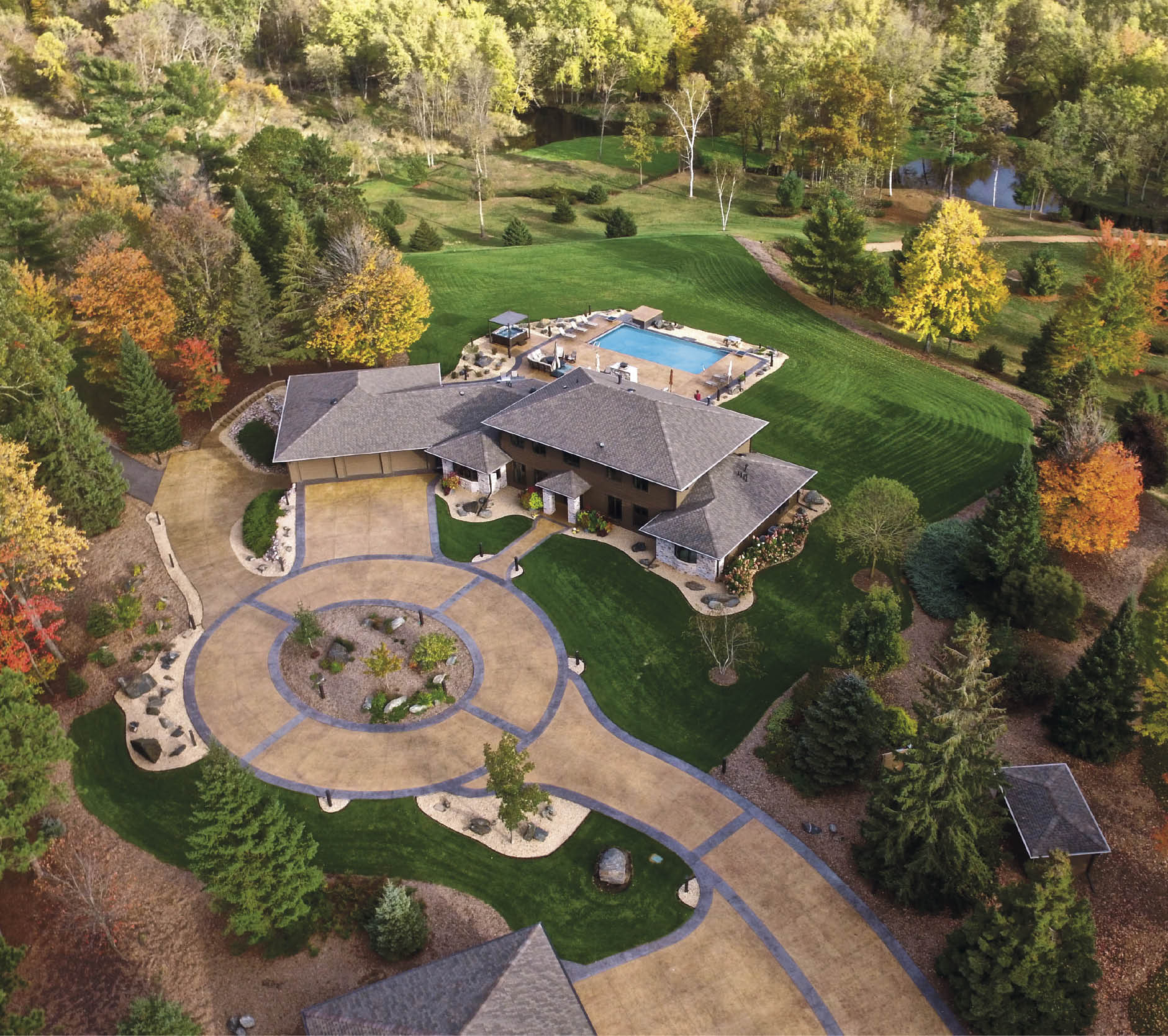Large scale home with a circular driveway features decorative concrete and a stamped and stained driveway.