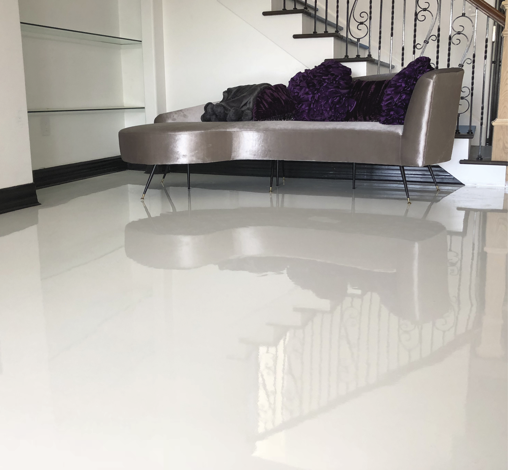 A clean white epoxy floor that is flanked with a white chaise lounge.