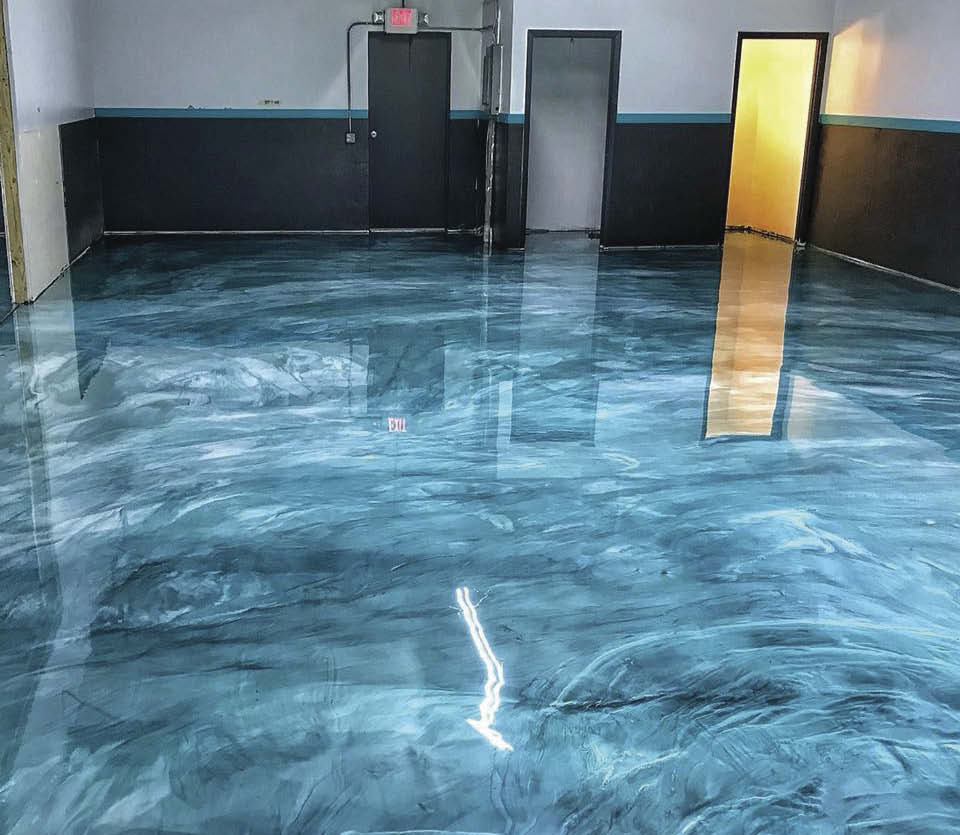 Blue sponsy on a concrete floor with black wainscoting.