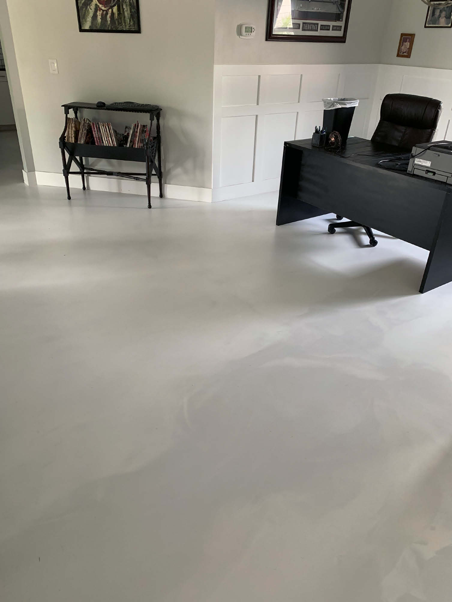 A clean floor with epoxy brings more attention to the dark colors of the furniture.