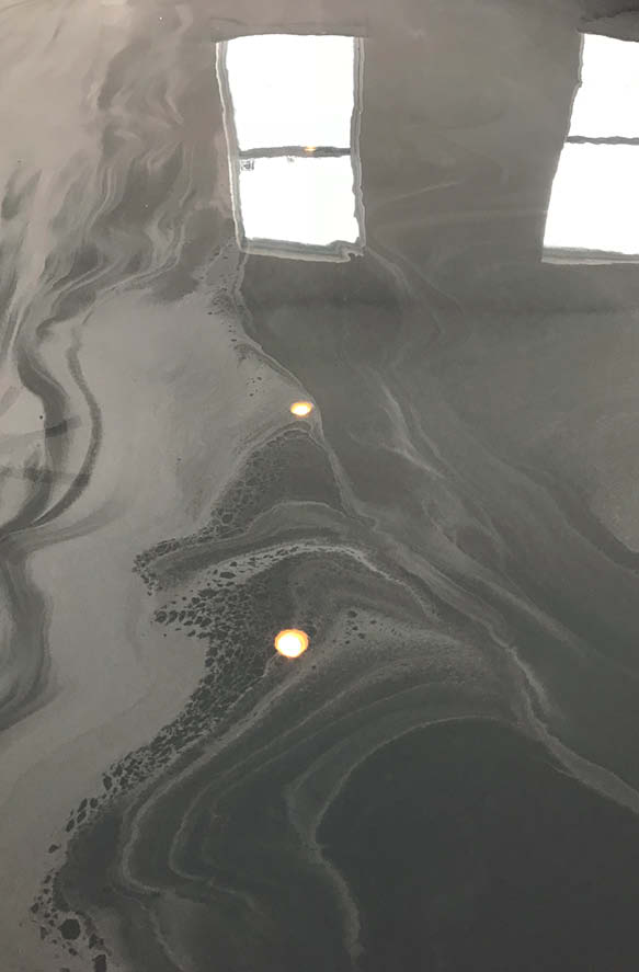 The swirls of epoxy floors reflect the lights above.