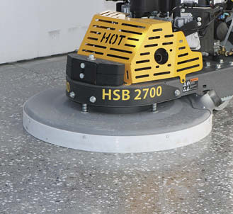 A polishing machine sits atop the concrete slab creating a space with a high sheen.