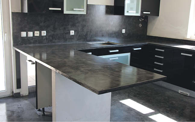 Dark concrete countertops in a kitchen with clean simple lines.