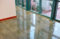 To get this polished concrete looking floor add color to the concrete sealer prior to applying the concrete sealer.