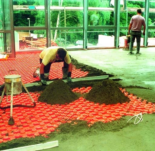 Screeding concrete over schluter system vapor barrier with radiant heating coils in the floor.