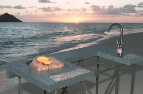 Outdoor concrete kitchen modeling on a beach in Hawaii during sunset.