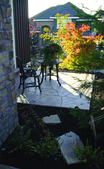 Small master bedroom courtyard that is stamped concrete that is colored and textured with iron furniture. 