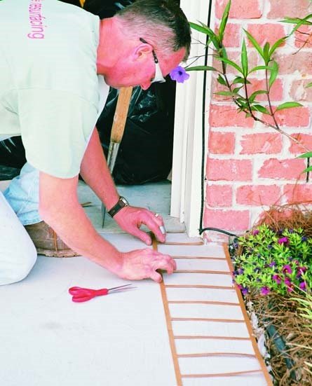 Cutting and measuring a brick stencil boarder prior to coloring.