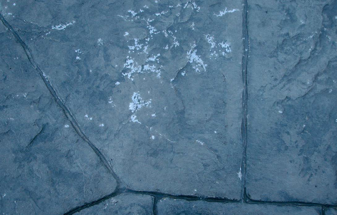 Sealer delamination, possibly due to salt or de-icing chemicals.