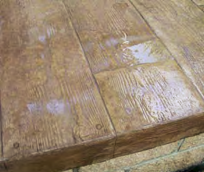 A water based sealer was applied, but the job got caught in the rain, washing excess sealer into the low-lying areas in the slab and causing this cloudy look.