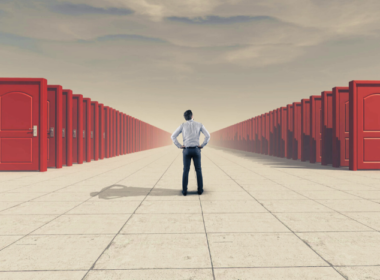 A man standing in front of many red doors