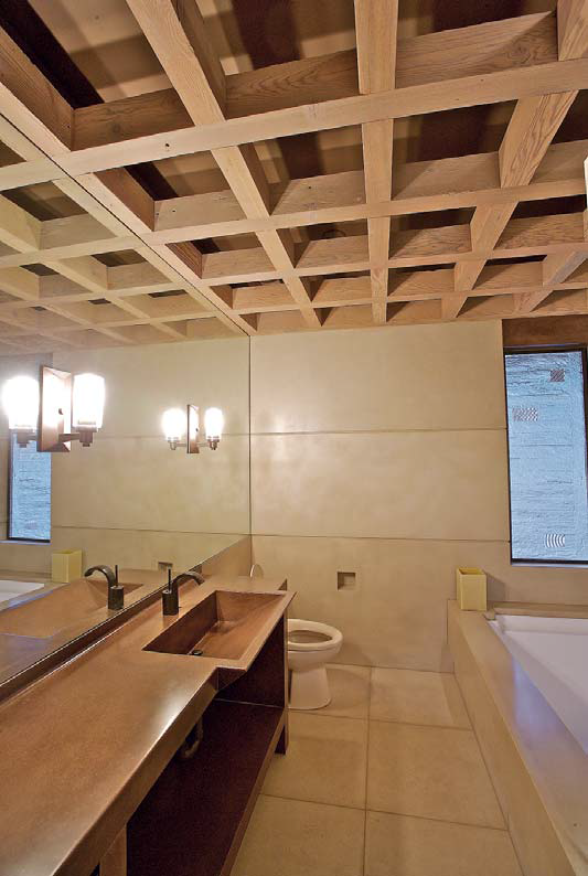 Lower bath: The bathroom features wall panels of tan concrete that support a grid of 4-by-6 sandblasted fir timbers. The beige colors contrast with the wood tones in the concrete sink and backsplash.