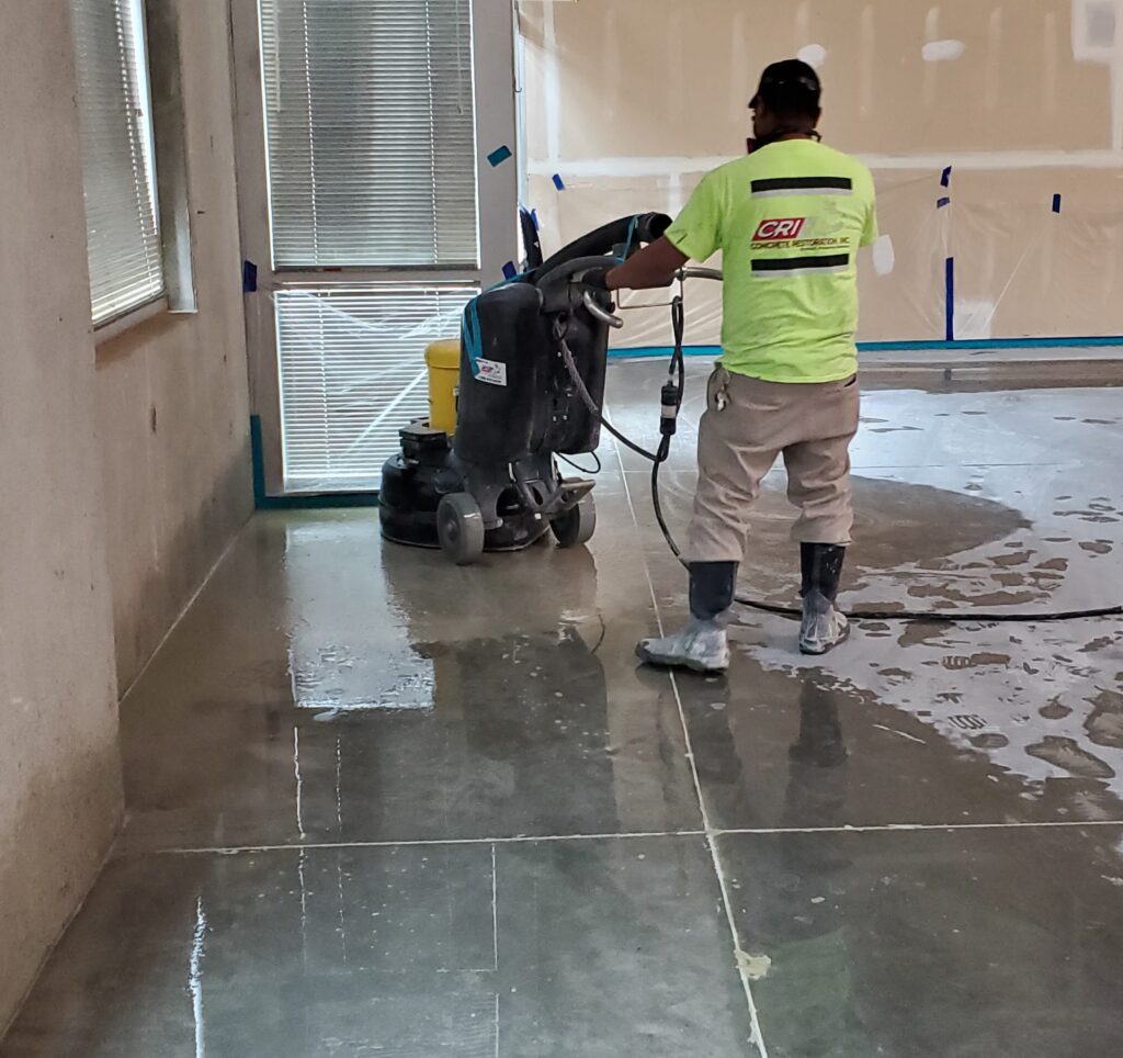 A polishing contractor using a grinder to polish a concrete floor.