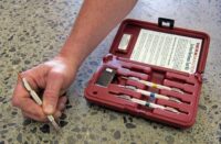 A hand next to a mohs testing kit