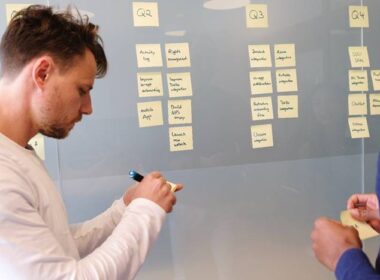 a man in front of a chalkboard with notes and post-its