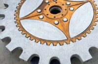 A cut of the concrete table that takes the shape of a machine cog