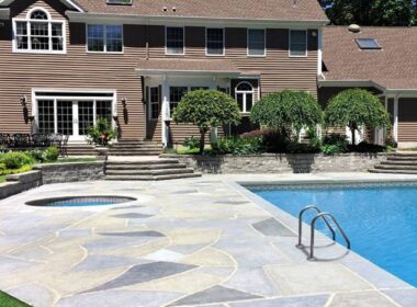 A pool deck finished with Renu-Krete products in front of a brown home