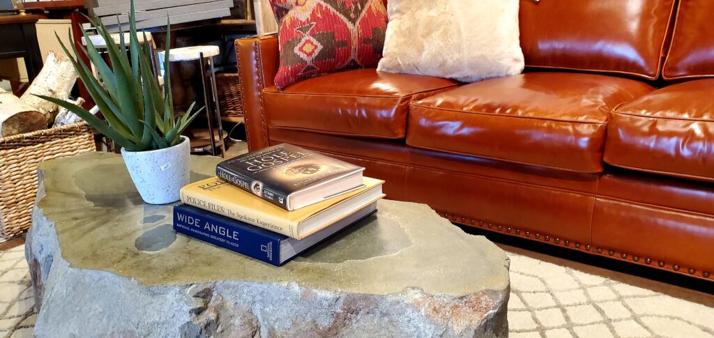 The carved rock coffee table on an area run in front of an orange couch.