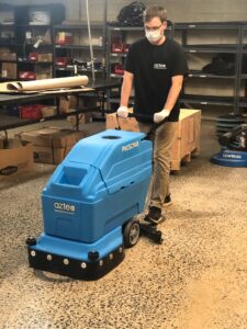 An auto-scrubber being used to clean a polished concrete floor.