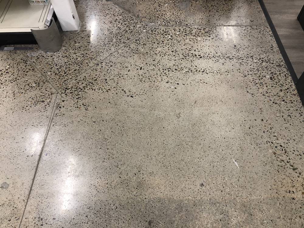 A concrete floor that has slab curl, making it challenging to achieve uniform aggregate reveal.